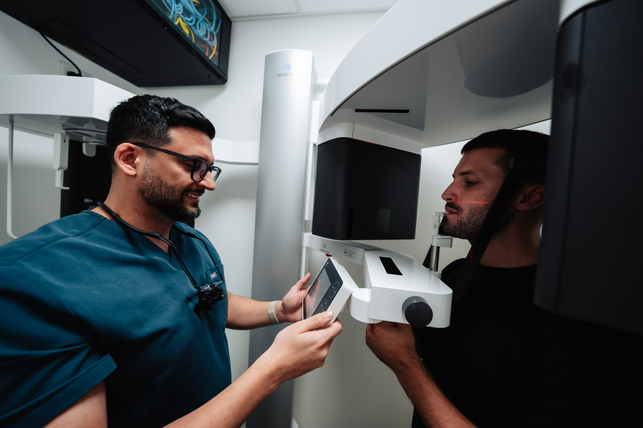Dentist using a CBCT scan to determine whether a bone graft and implant at the same time is suitable for the patient