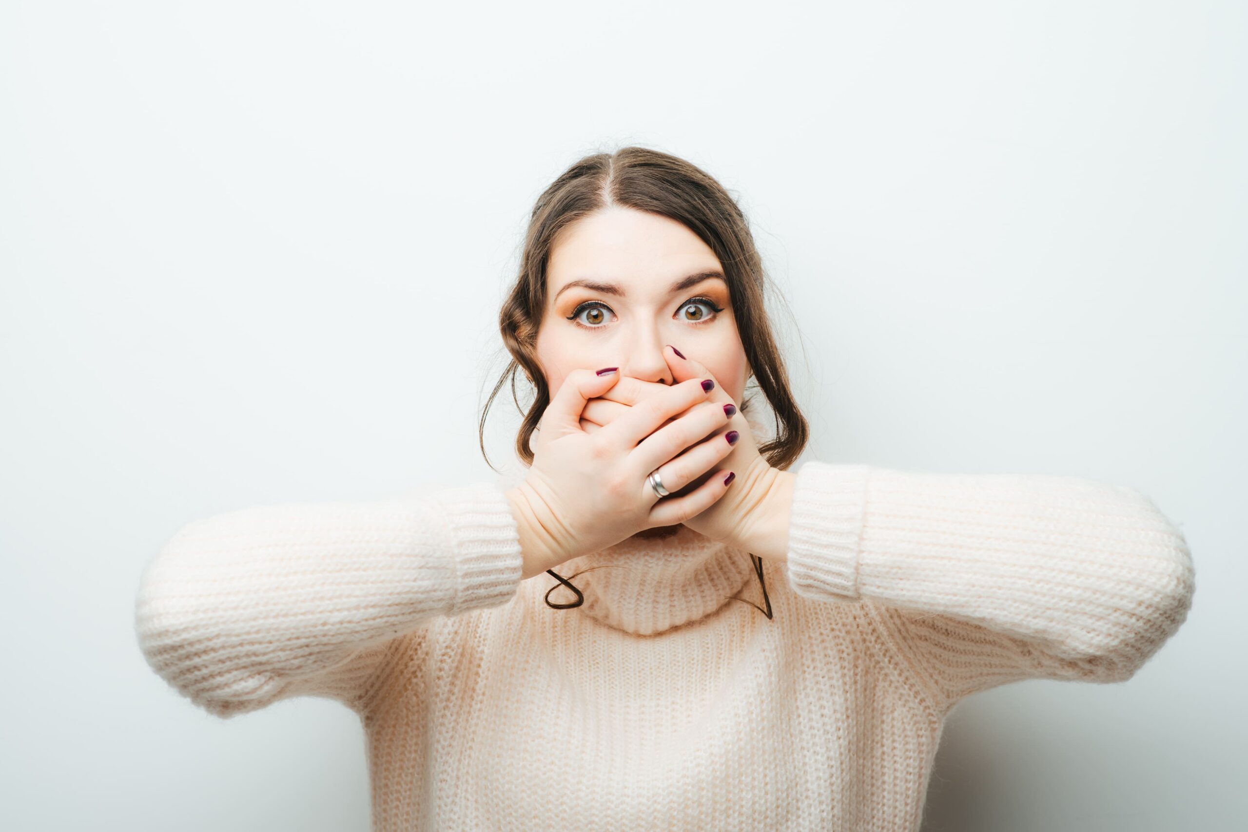 a woman covering her mouth due to severe dental anxiety