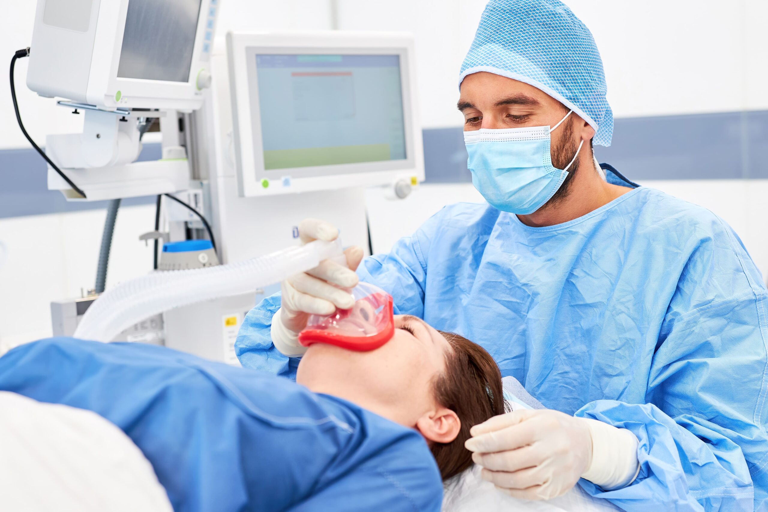 an anesthetist putting sleep dentistry mask over the patient's nose